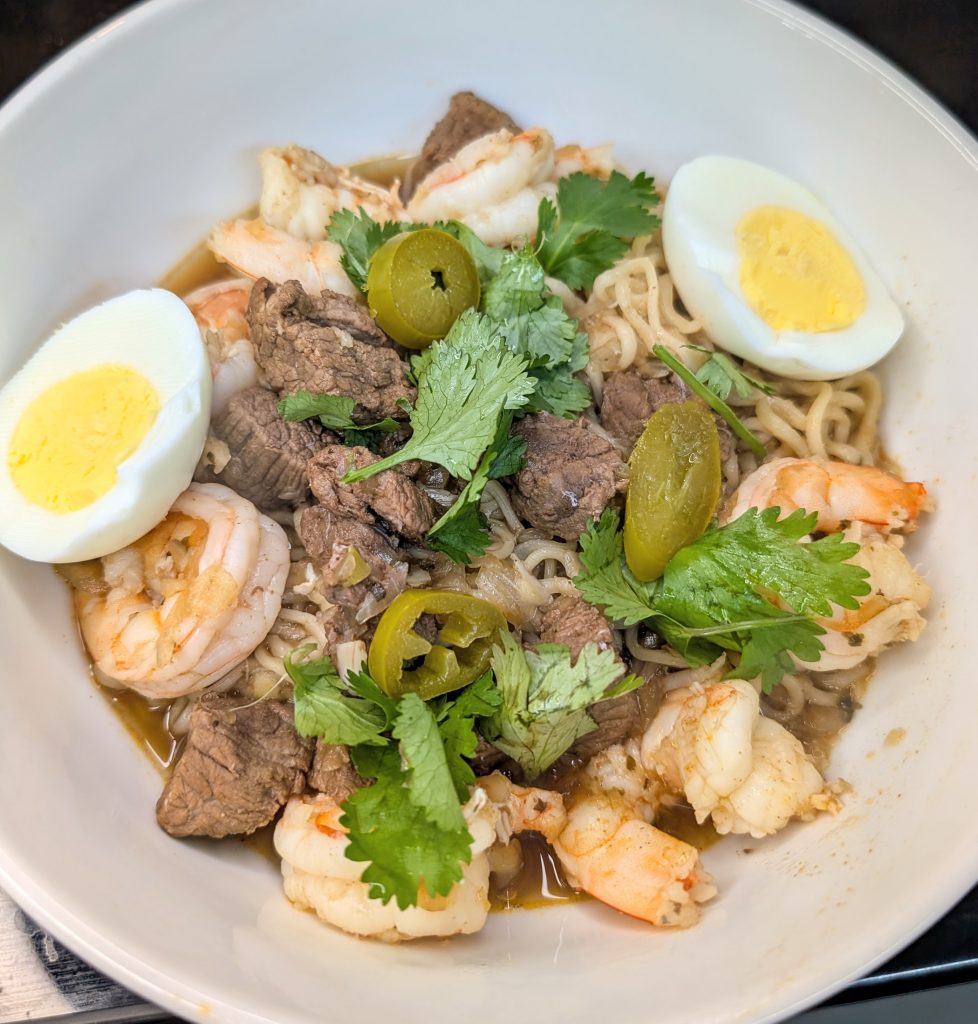 Organic New Orleans shrimp yakamein with beef, ramen noodles, boiled egg, cilantro, and jalapeños in beef bone broth